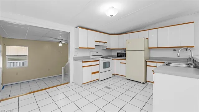 a kitchen with white cabinets and white appliances