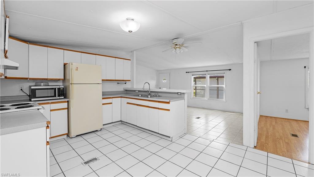 Undisclosed Address Naples, FL 34114 - Photo 5 of 20 a kitchen with white cabinets and white appliances
