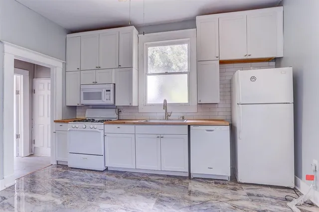 a kitchen with a refrigerator sink and cabinets
