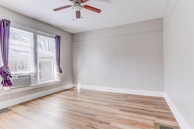 a view of wooden floor and chandelier fan in a room