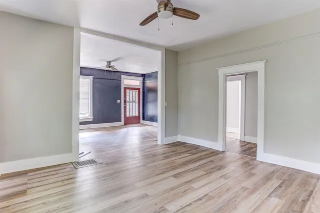 a view of an empty room with wooden floor