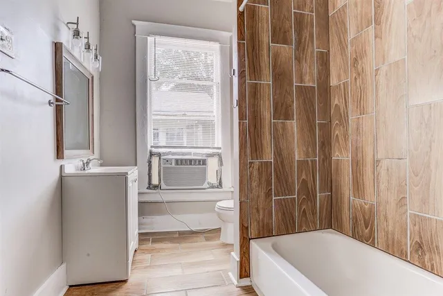 a bathroom with a tub shower and sink