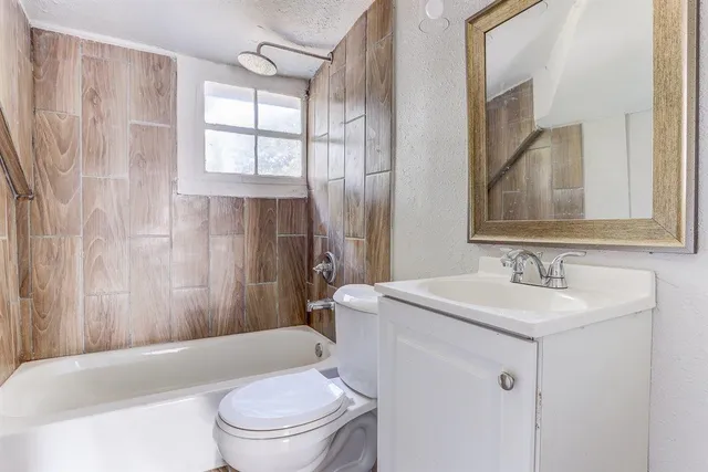 a bathroom with a sink toilet vanity and shower