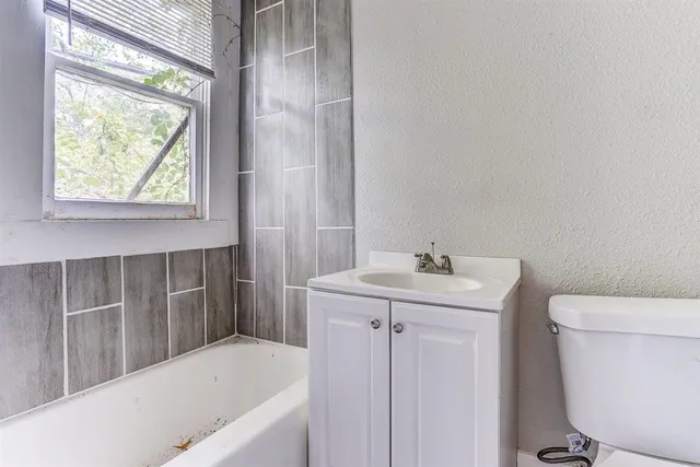 a bathroom with a sink a toilet and tub