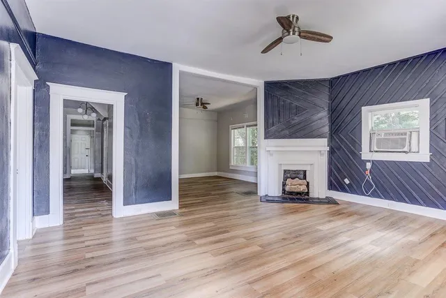 a view of a livingroom with wooden floor a fireplace and window