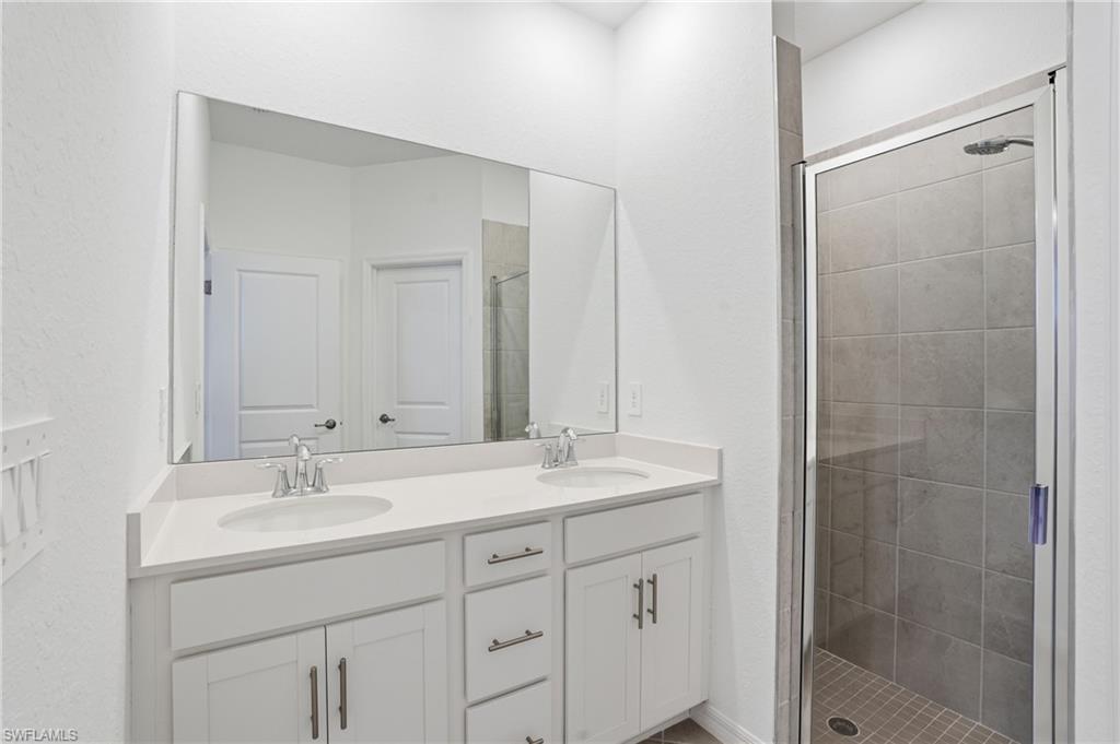 2215 Dragonfruit Way Naples, FL 34120 - Photo 24 of 38 a bathroom with a shower sink and mirror