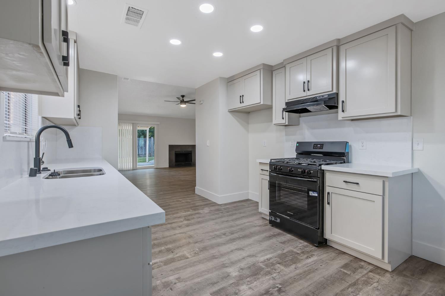 1249 Levich Street Hanford, CA 93230 - Photo 16 of 43 a kitchen with stainless steel appliances granite countertop a stove a sink and a refrigerator