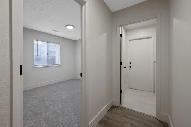 a view of an empty room with closet and a window