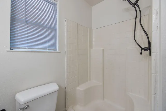a bathroom with a toilet and a shower