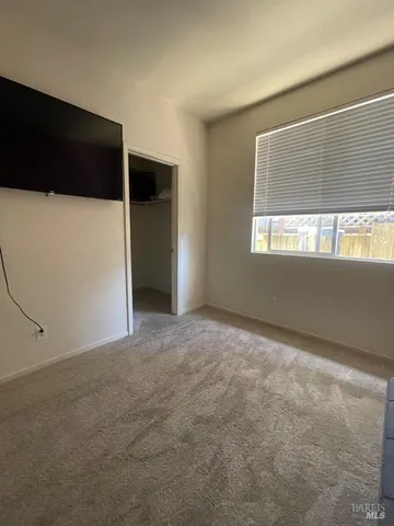 a view of a livingroom with an empty space and kitchen space