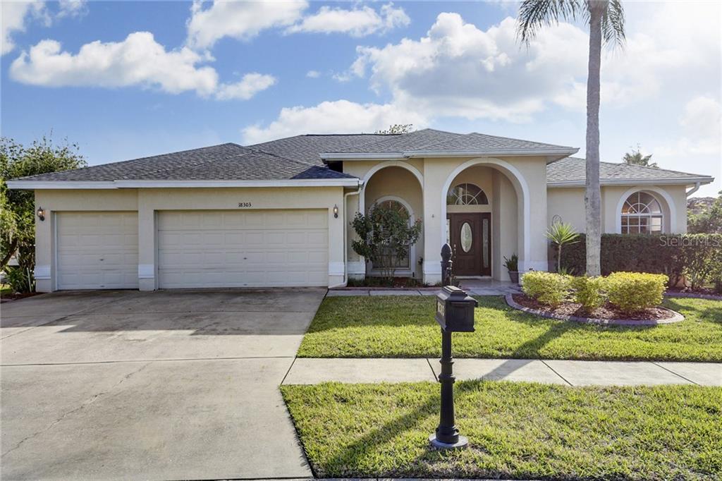 18303 Bittern Avenue Lutz, FL 33558 - Photo 1 of 1 a front view of a house with garden