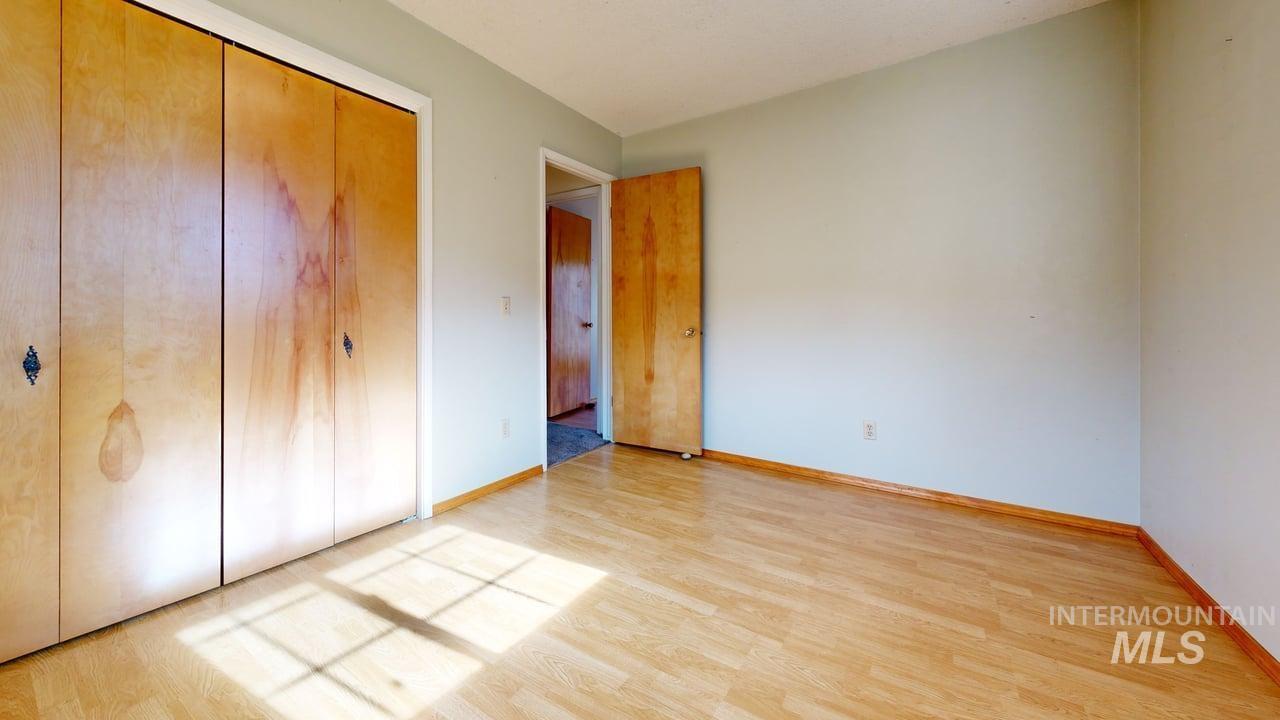 196 Main Street Juliaetta, ID 83535 - Photo 12 of 27 Unfurnished bedroom featuring light wood-style flooring and a closet