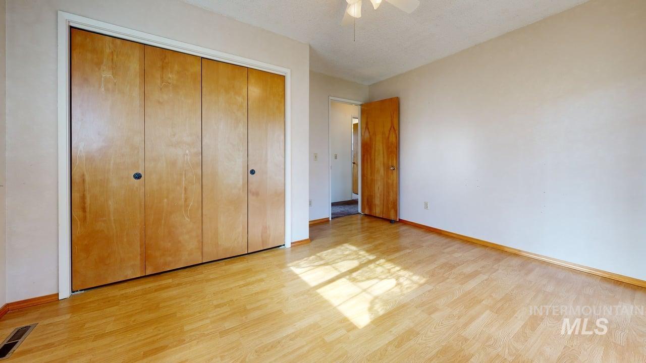196 Main Street Juliaetta, ID 83535 - Photo 14 of 27 Unfurnished bedroom with a closet, light wood-type flooring, ceiling fan, and a textured ceiling