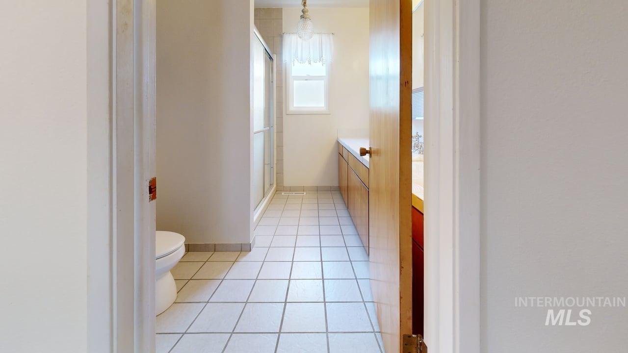 196 Main Street Juliaetta, ID 83535 - Photo 19 of 27 Bathroom featuring vanity, light tile patterned flooring, and a stall shower