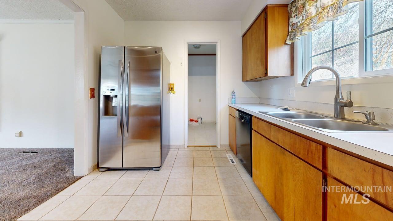 196 Main Street Juliaetta, ID 83535 - Photo 4 of 27 Kitchen with wood finish cabinetry, stainless steel fridge, light countertops, and dishwasher