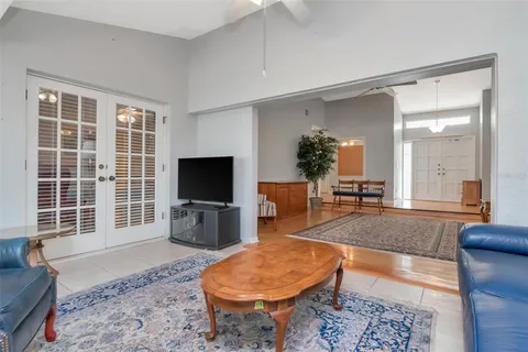 a living room with furniture a flat screen tv and a large window
