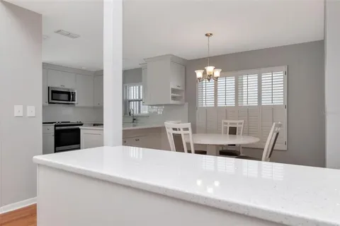 a large kitchen with granite countertop a sink a counter top space stainless steel appliances and cabinets