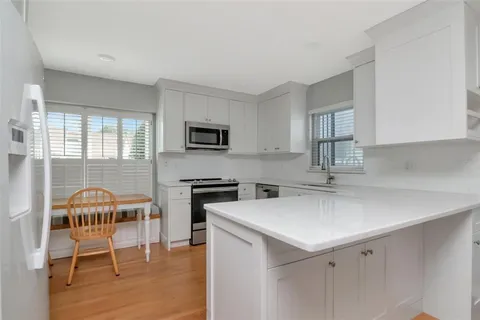 a kitchen with stainless steel appliances a stove a sink island and a refrigerator
