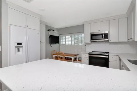 a kitchen with kitchen island a sink stainless steel appliances and cabinets