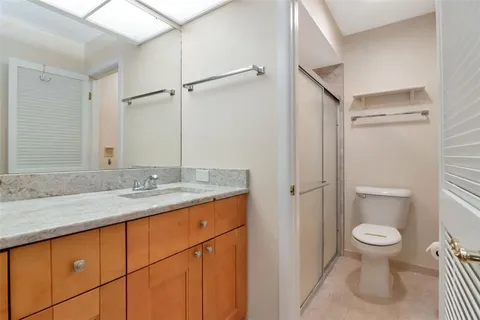 a bathroom with a granite countertop sink toilet and shower