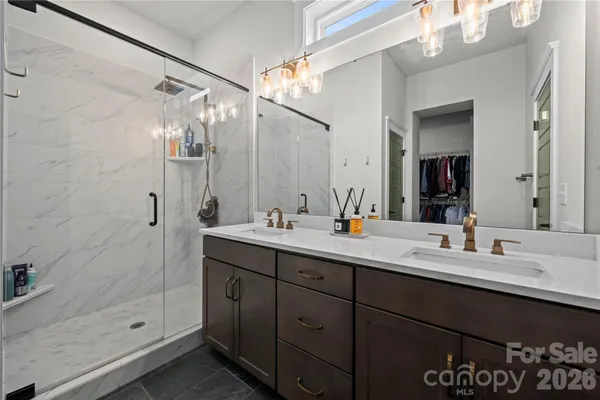 a bathroom with a double vanity sink mirror and shower