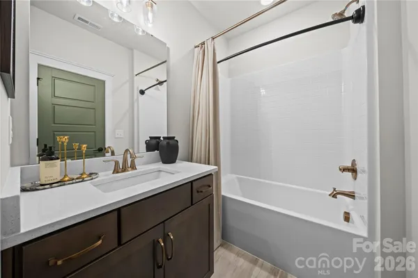 a bathroom with a tub sink and mirror
