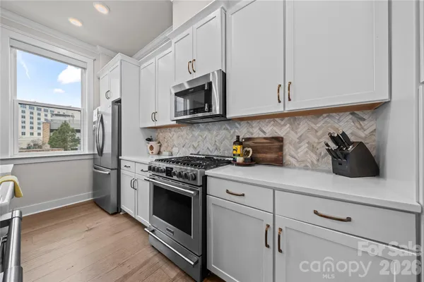 a kitchen with stainless steel appliances white cabinets and a stove top oven
