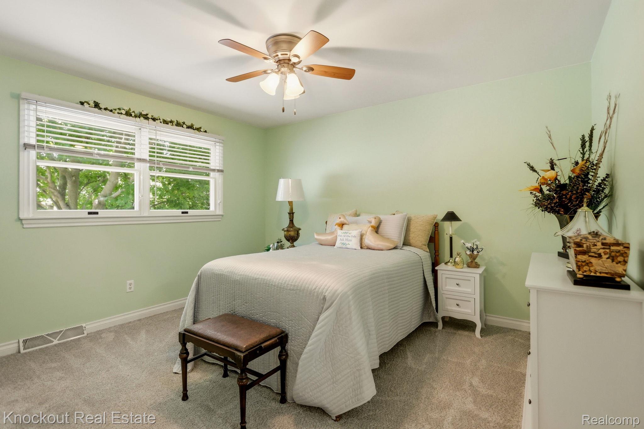 249 Churchgrove Road Frankenmuth, MI 48734 - Photo 23 of 44 Serene bedroom featuring soft sage-green walls, carpet flooring, and ample natural light from dual casement windows