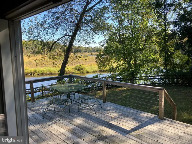 a view of swimming pool with chairs and wooden fence