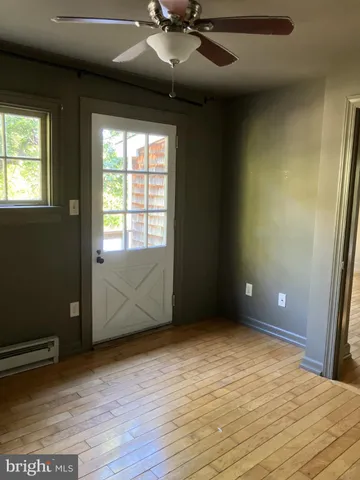 an empty room with wooden floor and windows