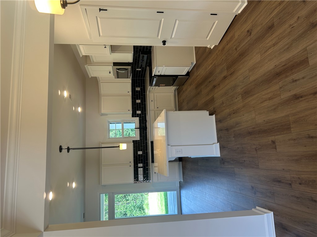 202 Bellflower Lane Pendleton, SC 29670 - Photo 7 of 27 A well-appointed kitchen showcasing elegant white cabinetry, dark tile backsplash, and a spacious island.