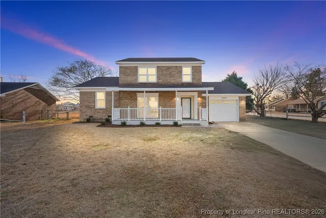 a view of a house with a yard and sitting area