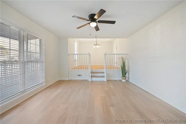 a view of a room with a ceiling fan and window