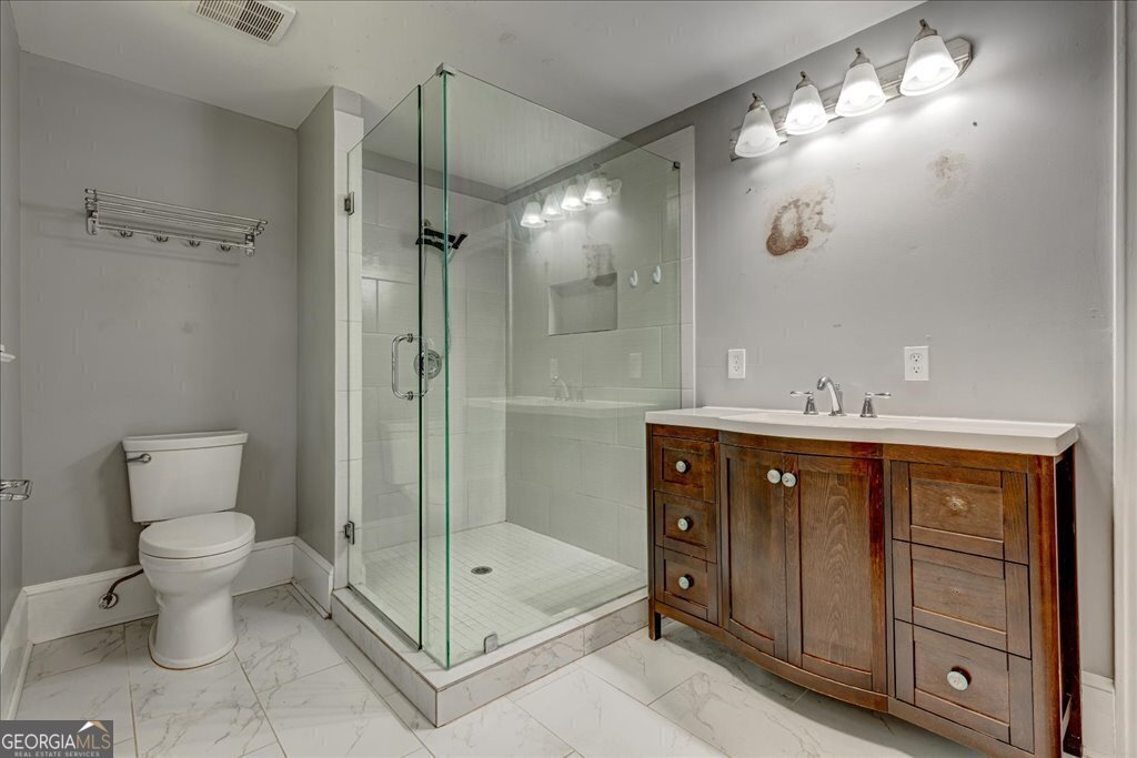 19 McDonough Street Hampton, GA 30228 - Photo 5 of 18 a bathroom with a sink a toilet and shower