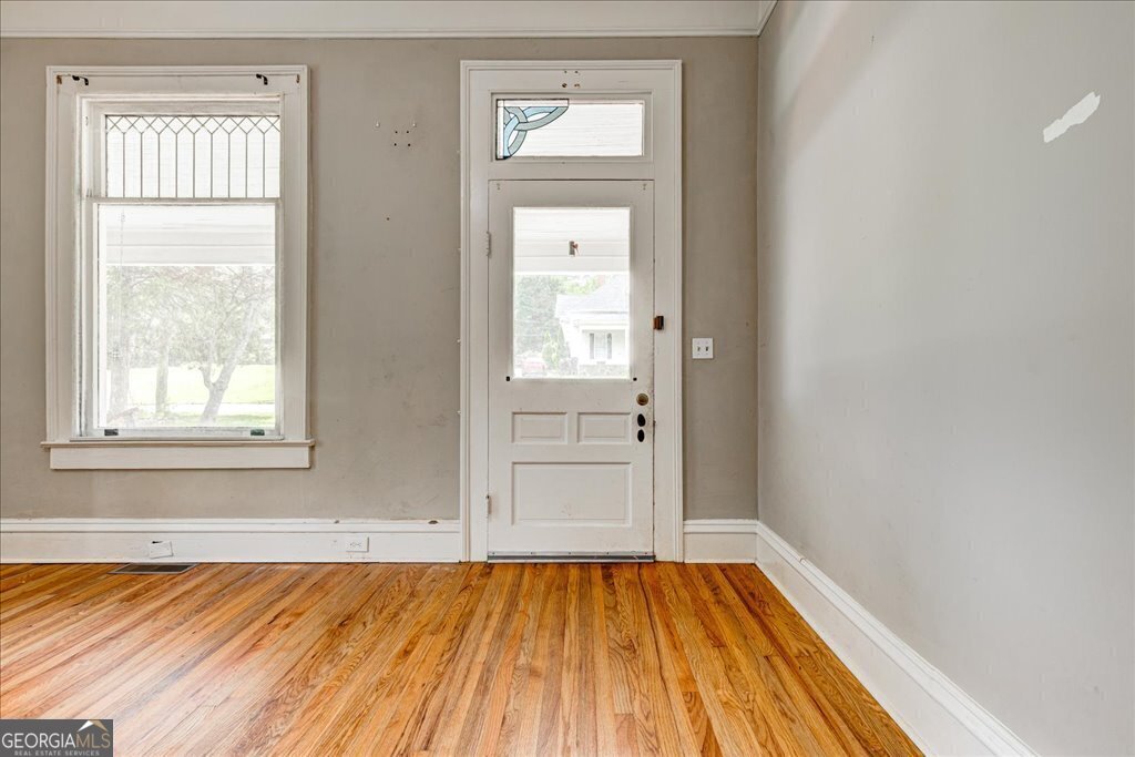 19 McDonough Street Hampton, GA 30228 - Photo 9 of 18 an empty room with wooden floor and windows