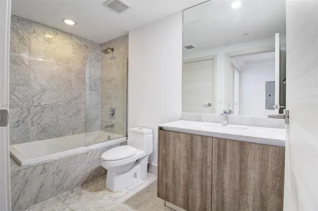 a bathroom with a sink a toilet and a large mirror