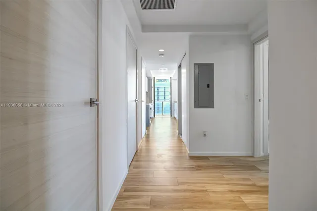 a view of a hallway with wooden floor