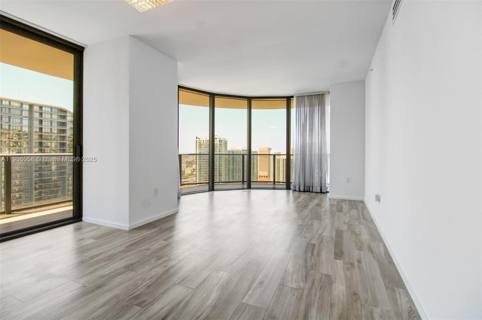 801 South Miami Avenue, Unit 4309 Miami, FL 33131 - Photo 7 of 34 wooden floor in an empty room with a window