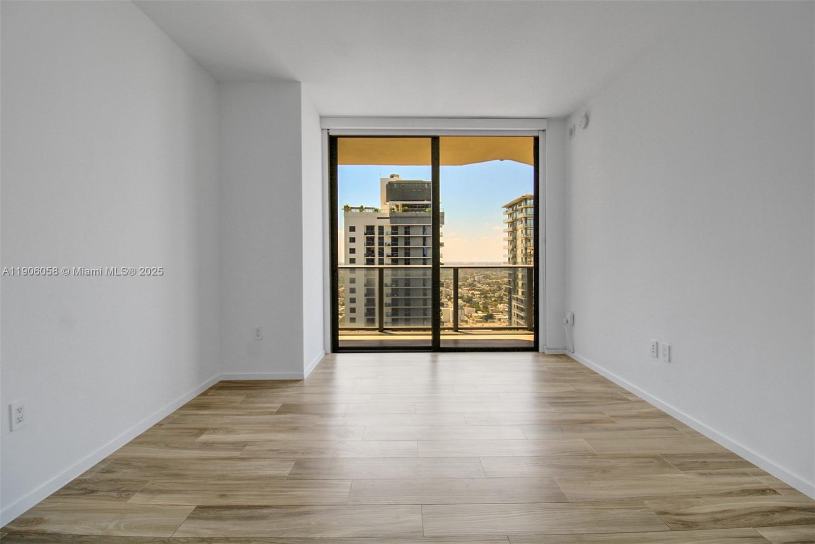 801 South Miami Avenue, Unit 4309 Miami, FL 33131 - Photo 9 of 34 a view of an empty room with wooden floor and a window