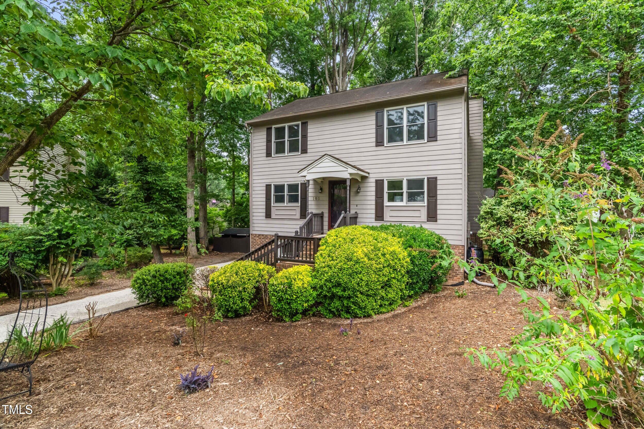 a front view of a house with a yard and trees