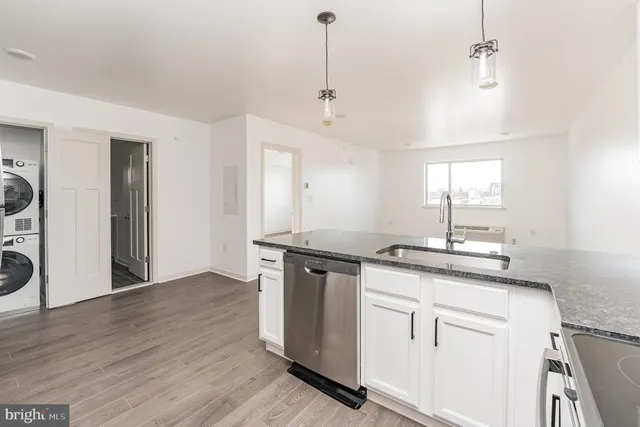 a kitchen with granite countertop a sink cabinets and wooden floor