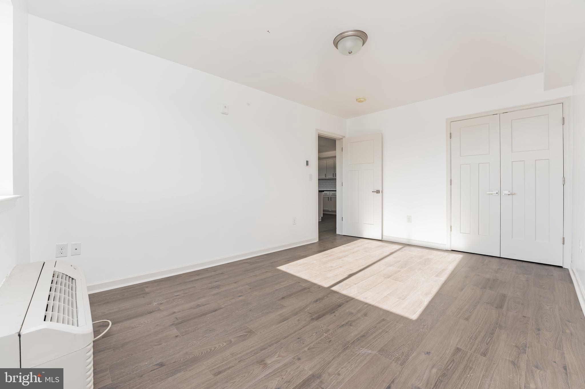 6649 Ridge Avenue, Unit A118 Philadelphia, PA 19128 - Photo 7 of 9 an empty room with wooden floor