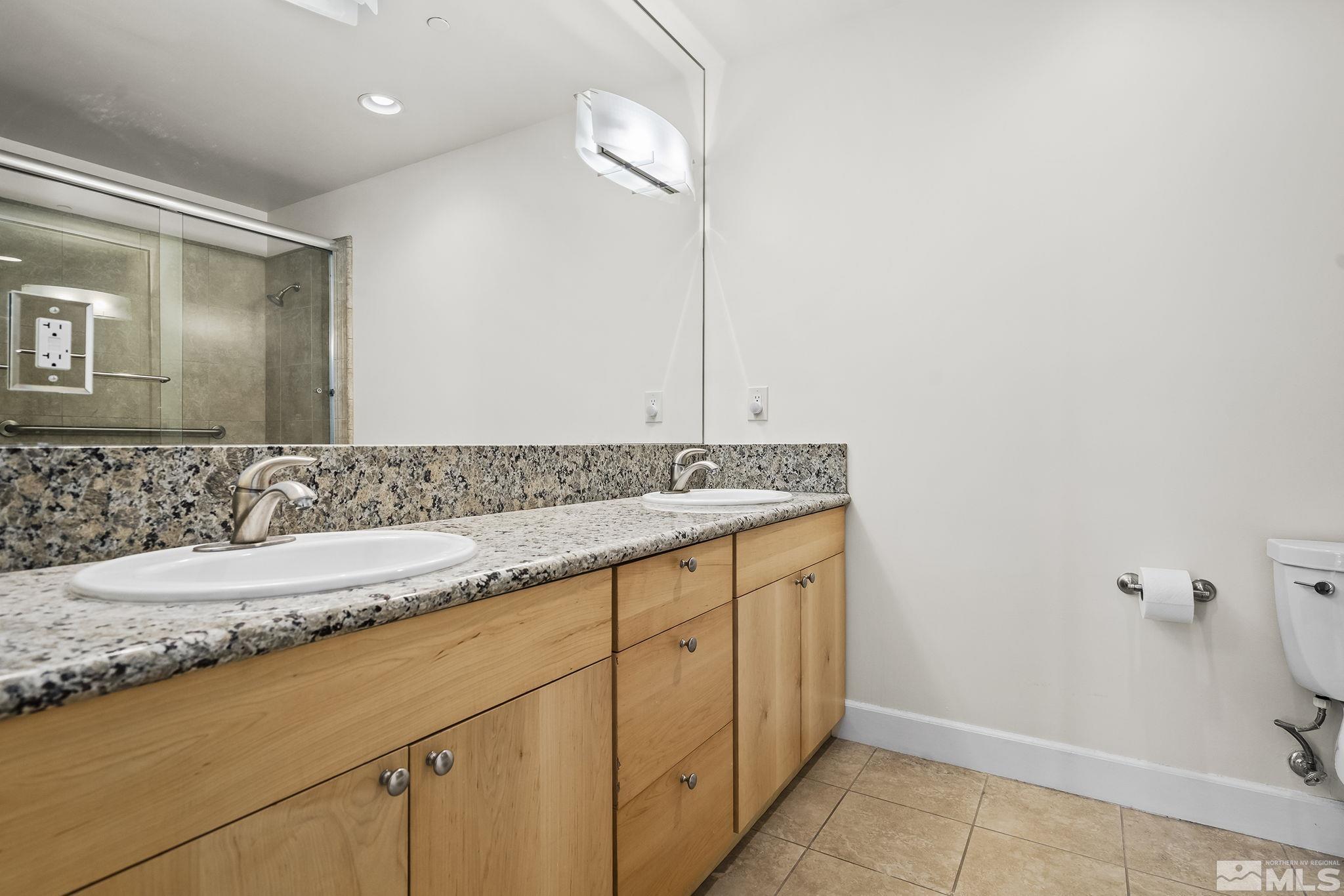 450 North Arlington Avenue, Unit 1207 Reno, NV 89503 - Photo 15 of 22 a bathroom with a granite countertop sink and a mirror