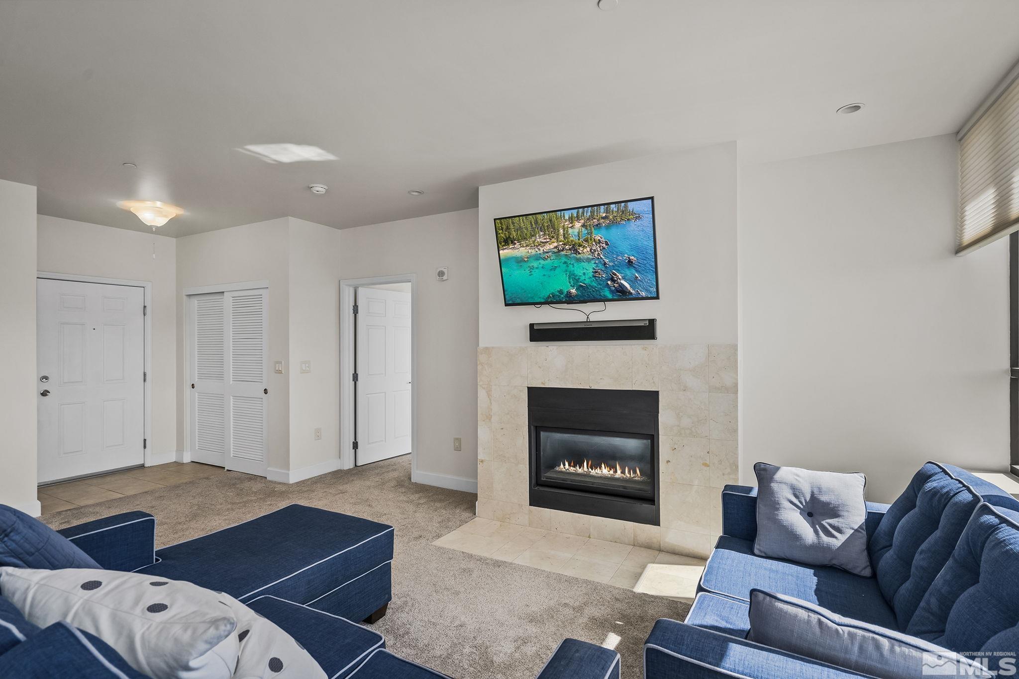 450 North Arlington Avenue, Unit 1207 Reno, NV 89503 - Photo 2 of 22 a living room with furniture a flat screen tv and a fireplace
