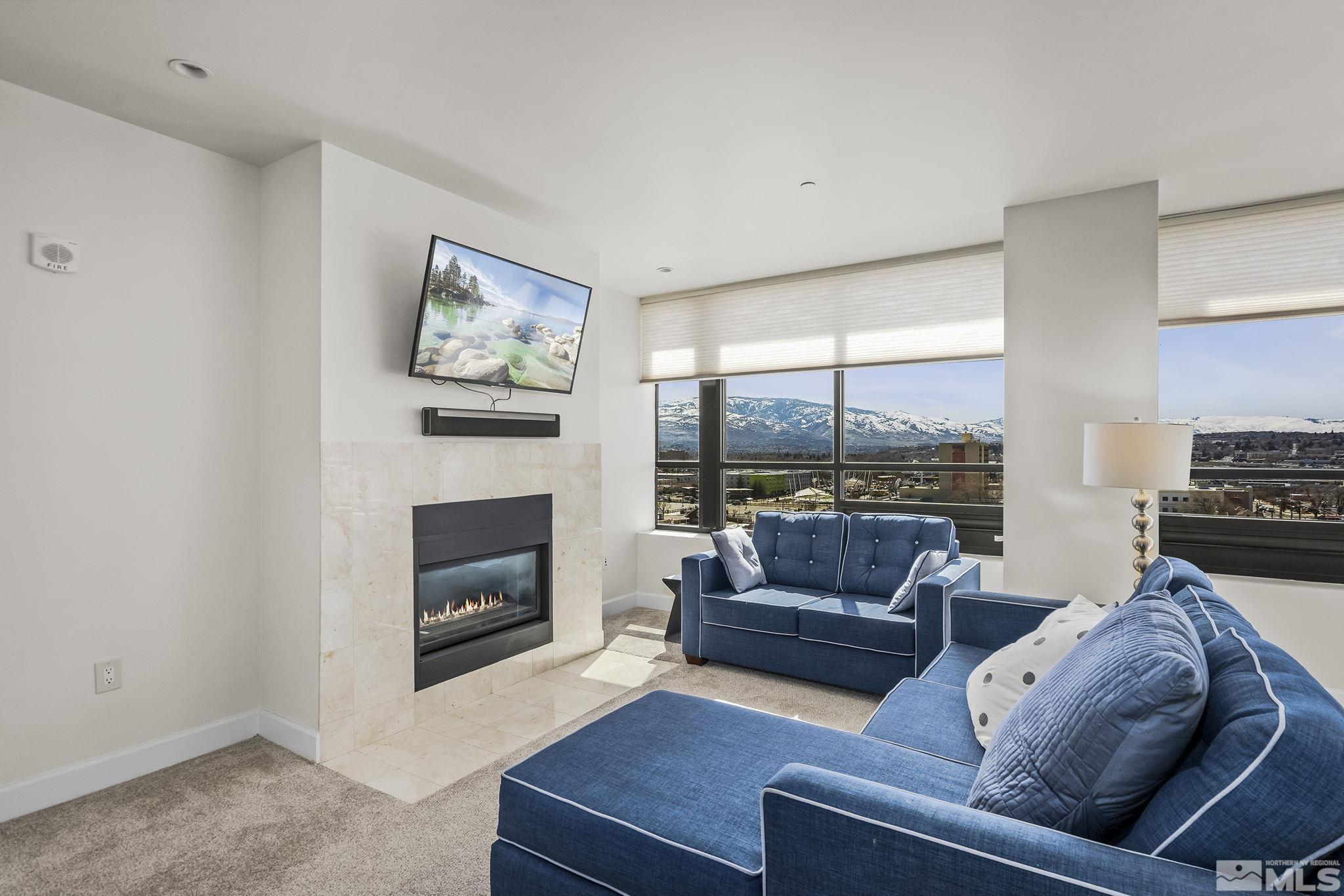 450 North Arlington Avenue, Unit 1207 Reno, NV 89503 - Photo 3 of 22 a living room with furniture a fireplace and a large window