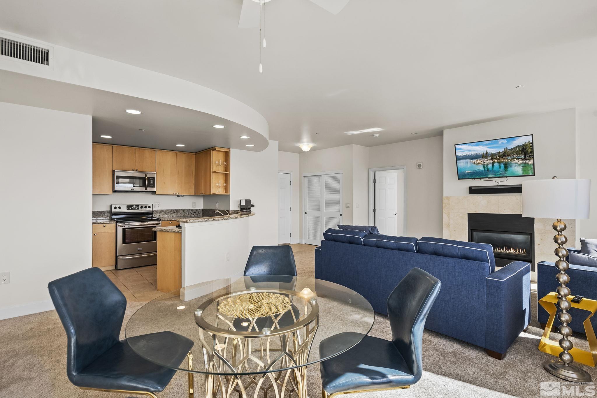 450 North Arlington Avenue, Unit 1207 Reno, NV 89503 - Photo 8 of 22 a kitchen with microwave a dining table and chairs