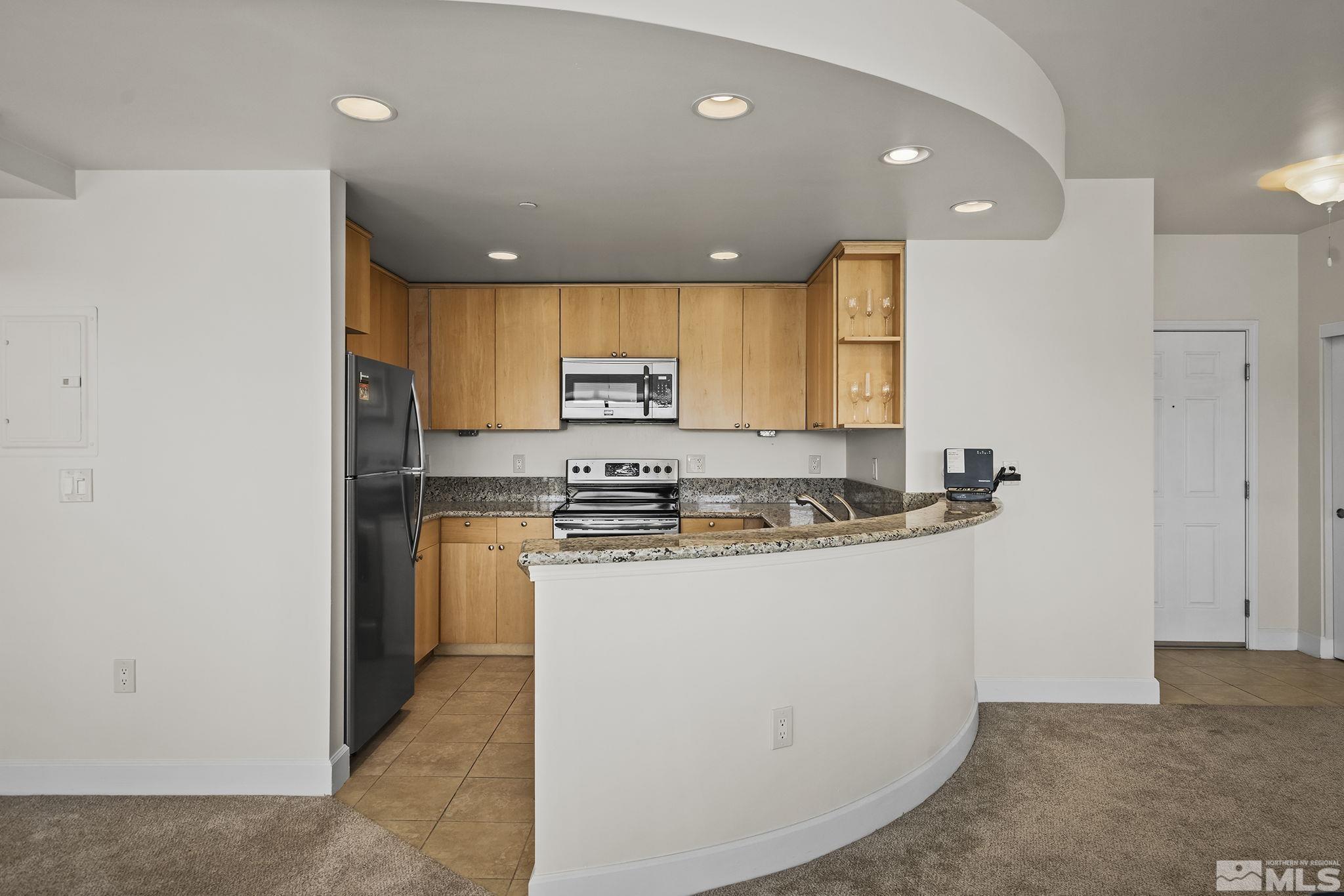 450 North Arlington Avenue, Unit 1207 Reno, NV 89503 - Photo 9 of 22 a kitchen with stainless steel appliances granite countertop a stove a sink and a refrigerator