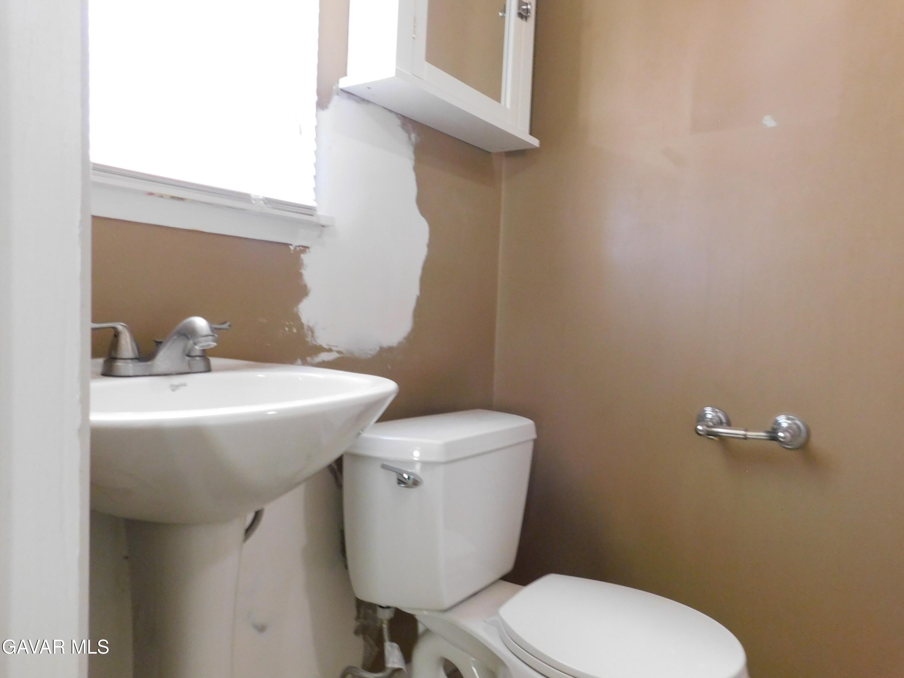 16873 Alexander Avenue Edwards, CA 93523 - Photo 21 of 31 a bathroom with a toilet a sink and mirror
