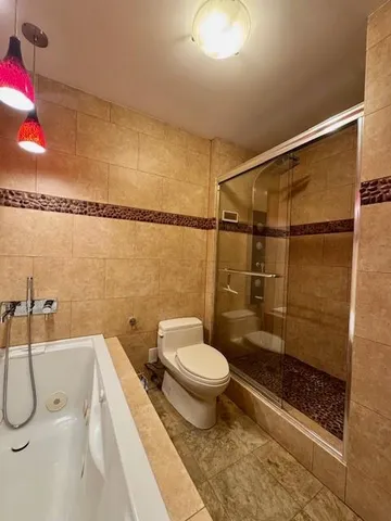 a bathroom with a toilet and a shower