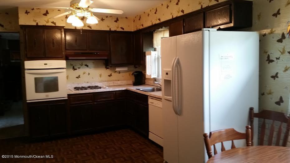 51 Hidden Stream Road Freehold, NJ 07728 - Photo 4 of 21 a kitchen with granite countertop a refrigerator a microwave a sink and cabinets